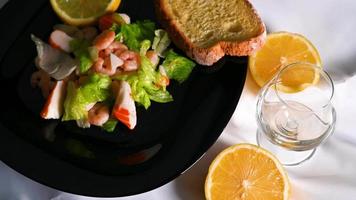 Zusammensetzung von Fischsalat auf schwarzem Teller video