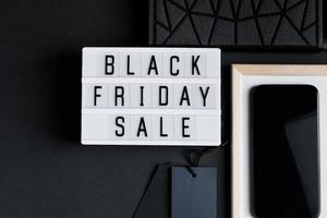 Black Friday sale. Smartphone and accessories on dark background. photo