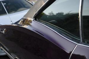 Rear window and curvy door details of a purple classic american car photo