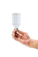 Human hand holding LED light bulb isolated on white background photo