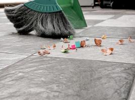 limpiar los suelos de baldosas con una escoba y un recogedor de plástico