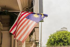 Old torn Malaysia flag in big city Kuala Lumpur, Malaysia. photo