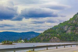 Driving through Norway in summer with mountains and fjord view. photo