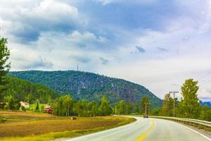 conduciendo por noruega en verano con vistas a las montañas y al fiordo. foto