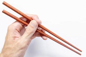 Man holding chopsticks on white background photo