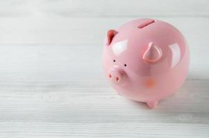 Pink Piggy bank on white wood floor photo