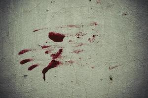 Red blood like hand shape stuck on the grunge wall photo