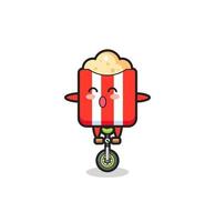 el lindo personaje de las palomitas de maíz está montando una bicicleta de circo vector