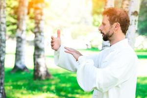 An instructor practice of Tai Chi Chuan in the park. photo