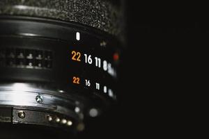 Camera lens with aperture numbers on a black background photo