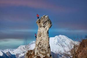 Roped by two male and female climbers on the wall photo