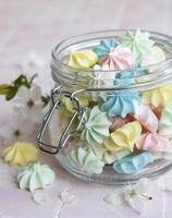 Small colorful meringues in the glass jar photo