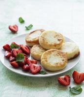 Cottage cheese pancakes, ricotta fritters on ceramic plate photo