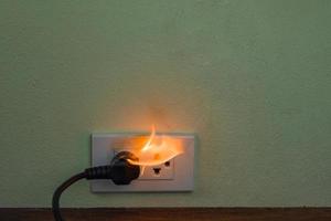 Enchufe de cable eléctrico en llamas foto