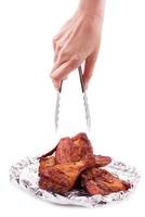 Hand holding serving roasted chicken in aluminum foil photo