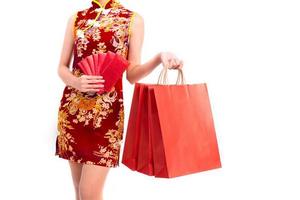 Lower body of Asian woman wearing cheongsam carry red packet of money photo