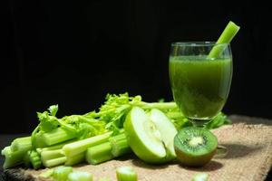 Blended mixed juice celery and kiwi green apple in welcome drink glass photo