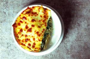 Spinach lasagna with cheese in white plateasagna photo