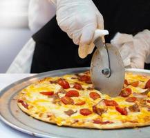 Slicing Fresh Made Italian Pizza photo