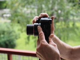 Unrecognisable person holding camera with both hands photo