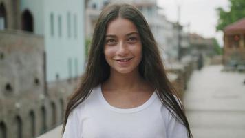 Smiling young woman looking at camera on street video