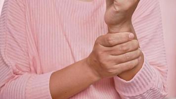 Closeup of female holding her painful wrist caused by prolonged work. video