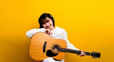 capacidad para tocar la guitarra niña asiática una hermosa mujer tocando foto