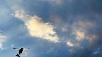 helicóptero está passando no céu nublado do pôr do sol video