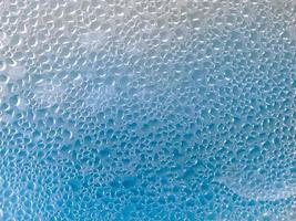 fondo azul de gotas de agua sobre el cristal foto