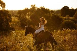 niña en un caballo de hierba alta foto