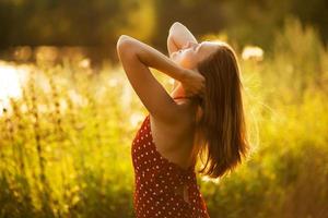 mujer feliz en los rayos del sol vespertino foto