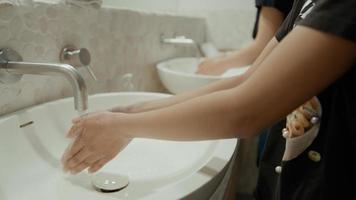 Woman and girl washing hands in bathroom