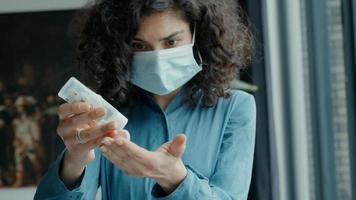 mujer con mascarilla desinfecta las manos foto