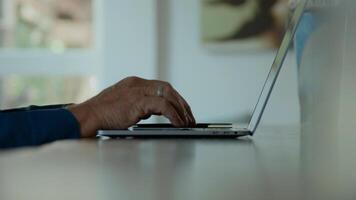 Hands of man typing on keyboard of laptop and man nods photo