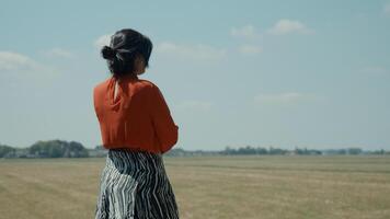 Mujer de pie en el campo llamando con smartphone foto