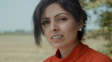 Woman in rural area looks up into camera lens photo