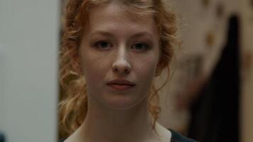 Close up of young white woman, looking into camera lens, blinking photo