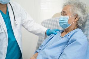médico ayuda al paciente mayor asiático con máscara para proteger el coronavirus foto