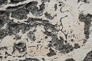 Plastered gray stone surface with cracks photo