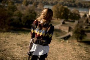 Young woman standing outside at sunny autumn day photo