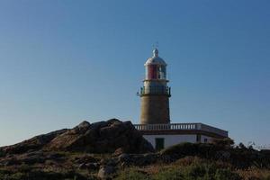 Faro de Corrubedo en el océano Atlántico, Galicia, España foto