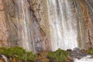 Water cascading over a small lake photo