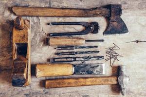 Old construction tools on a wooden workbench flat lay background photo