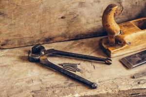 Old rusty pincers on a wooden background photo