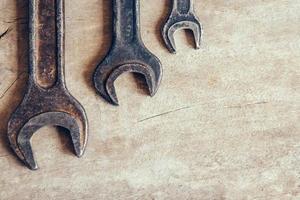 Different old wrenches on a wooden background and copy space. Top view photo