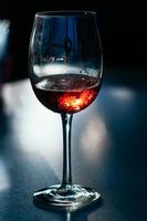 A glass of wine on dark background photo