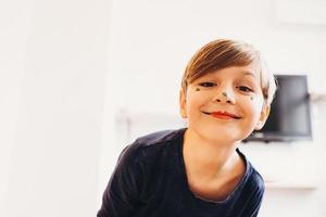 cute boy with a face painted as a clown, smiling photo