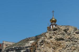 paisaje con una capilla cristiana en una roca foto