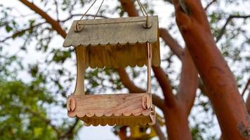 Wooden bird feeders on a blurry background of trees