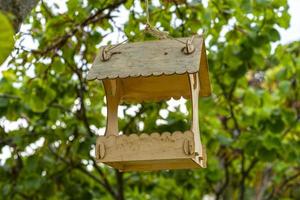 Wooden bird feeders on a blurry background of trees photo